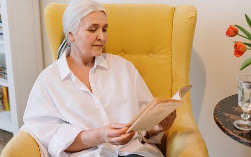 Elderly man reading a book in a chair