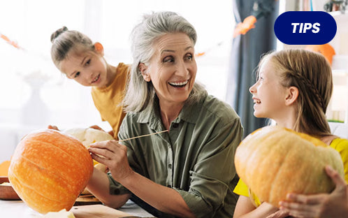 seniors and kids carving Halloween pumpkins