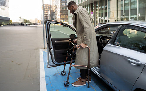 A man using a walker after getting out of the car.