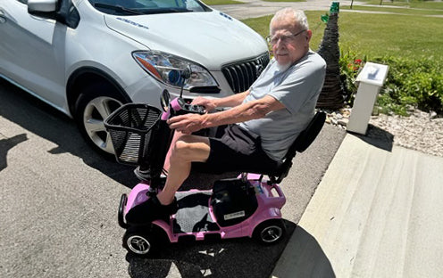 Alvin McFarland is driving his pink D41 mobility scooter outside