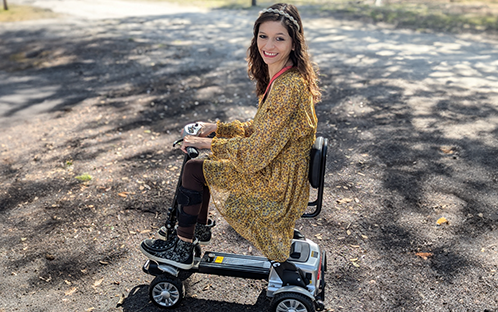 Charisse with D71 mobility scooter outside