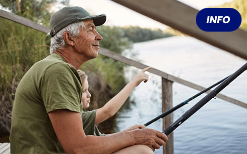 A senior is fishing with his grandson