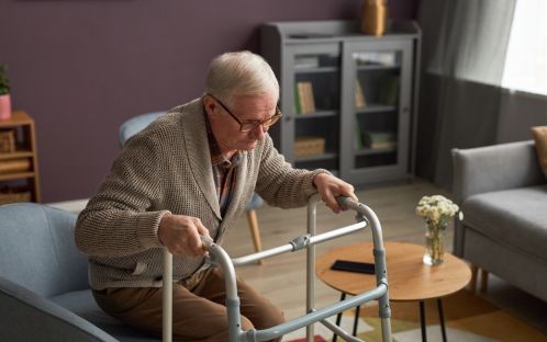 Elderly people using walkers to get up from a chair