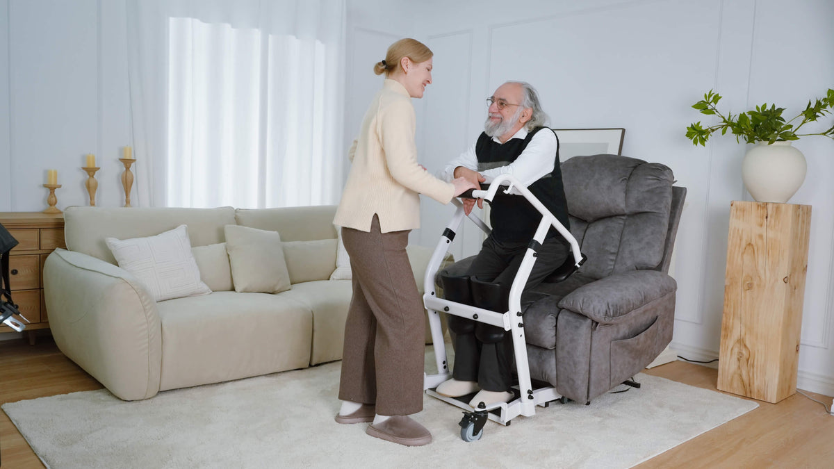A caregiver assisting an older man with a standing transfer aid at home.